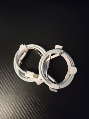 Vita USB-C till USB-C flätade kablar - Två stycken vita USB-C till USB-C kablar med flätad textilsladd. Perfekta för laddning och dataöverföring till mobiltelefoner och andra enheter. Kablarna har en stilren design och känns tåliga tack vare det slitstarka materialet.