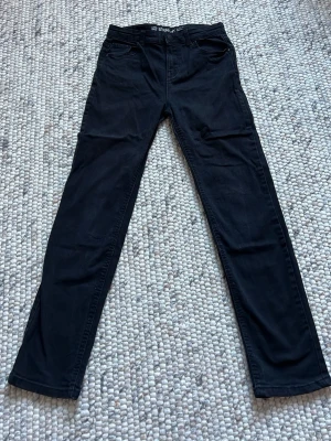 Svarta slim fit jeans  - Säljer ett par svarta slim fit jeans. Jeansen har klassisk femficksdesign, normal midja och raka ben. Materialet är stretchigt för extra komfort. Perfekta till en avslappnad look och passar till det mesta.