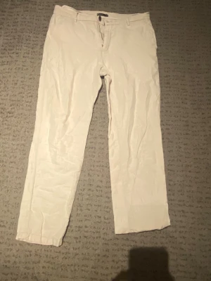 Beiga linnebyxor - Säljer ett par stilrena beiga linnebyxor med raka ben och klassisk passform. Byxorna har knapp och dragkedja framtill samt hällor för skärp. Perfekta för en avslappnad och trendig look. Materialet är lätt och luftigt linne.