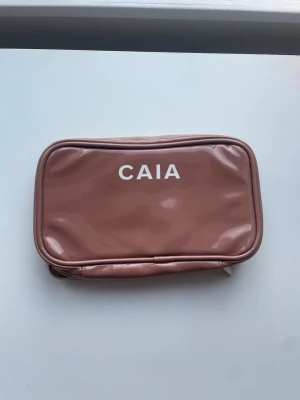Caia necessär - Säljer denna Caia necessär som inte längre säljs på hemsidan. Den är brun och i nyskick förutom några små sminkfläckar inuti men som knappt syns. På utsidan är den helt fläckfri.