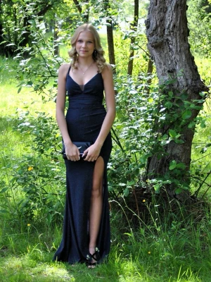Mörkblå långklänning med slits - Säljer en elegant mörkblå långklänning med djup urringning och hög slits framtill. Klänningen har tunna axelband och snygg snörning i ryggen som ger en unik detalj. Perfekt för bal eller festliga tillfällen.