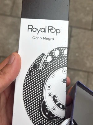 Royal Pop Ocho Negro förpackning - Säljer en Royal Pop Ocho Negro-förpackning. Designen är svartvit med ett grafiskt mönster på framsidan. Perfekt för dig som gillar unika och stilrena förpackningar. Produkten är rektangulär och har en modern look.