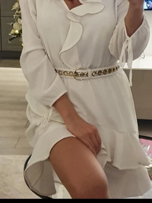 Vit omlottklänning Patrizia Pepe  - Beautiful and feminine white dress from the exclusive Italian designer brand Patrizia Pepe.   ✔️ Size 1 (equivalent to EU 36 / S) ✔️ Like-new condition ✔️ Elegant textured fabric ✔️ Flattering V-neckline ✔️ Romantic ruffle details ✔️ Delicate metallic bead trim along the ruffles ✔️ Long sleeves with tie details ✔️ Lightweight and comfortable fit  Please note: The belt shown in some photos is not included, as it does 