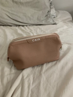 Caia necessär (finns inte längre) - från caia denna finns inte längre att köpa. Är i nästan nyskick då det bara varit i en låda. Så utsidan är utan defekter. Har dock haft lite näsdukar i den och handkräm. Men vet inte hur de små vita prickarna kommer ifrån. Se bilder” men de syns knappt.