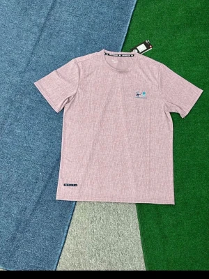 Ljusrosa kortärmad t-shirt - Säljer en ljusrosa t-shirt med diskret mönster och rund hals. T-shirten är kortärmad och har en liten logga på bröstet samt en etikett nertill. Perfekt för en avslappnad stil.