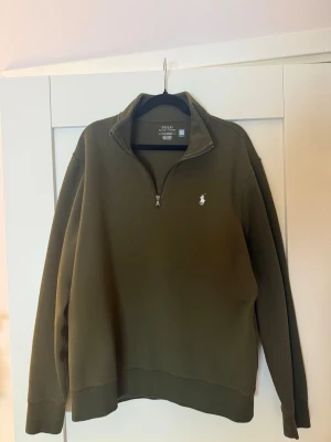 Olivgrön half-zip från Polo Ralph Lauren - Säljer en olivgrön half-zip sweatshirt från Polo Ralph Lauren. Tröjan är beställd från deras egna hemsida och kostar 2400kr. Tröjan är i mycket bra skick och är perfekt inför hösten och vintern.