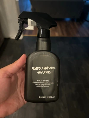 LUSH Honey I Washed The Kids Body Spray - Honey I Washed The Kids Body Spray från LUSH i svart plastflaska med spraymunstycke. Doftar av söta honungskarameller och har en twist av brasiliansk apelsin. Flaskan rymmer 200 ml och uppskattar att det är ca 75% kvar. Förvarats mörkt och svalt. 
