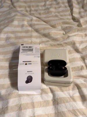 Sony WF-1000XM5 trådlösa in-ear - Sony WF-1000XM5 är svarta trådlösa in-ear hörlurar med laddningsetui. De har en stilren och kompakt design, touchkontroller och flera silikonpluggar i olika storlekar. Perfekt för musik, poddar och samtal. USB-C laddkabel och originalförpackning medföljer. Säljer då jag själv använder airpods