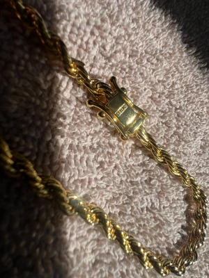Guldarmband Karat Jewelry - Snyggt armband i flätad guldlänk från Karat Jewelry. Armbandet har en elegant och glansig finish med ett robust lås i guldton. Perfekt accessoar för dig som gillar klassisk och stilren design. Kommer i original ask.