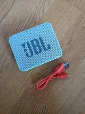 JBL GO 2 i MINTGRÖN - JBL GO 2- högtalare i mintgrön färg. Högtalaren har tydliga knappar på ovansidan för volym och Bluetooth samt medföljande orange USB-laddkabel. Perfekt för att ta med sig överallt. !!Vattentät så länge locket till porten är ordentligt stängt!! Markerar den som "good condition" för att den varit välanvänd- dock är den också mycket väl omhändertagen, så utseendemässigt ser den nästan ut som ny och fungerar som den ska! Den har en pytteliten "skrapa" på L:et som syns på bild nr 1.