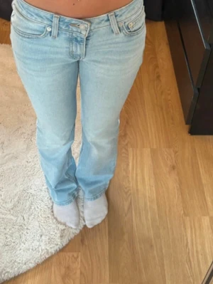 Ljusblå bootcut jeans från Levi's - Säljer ett par ljusblå lågmidjade bootcut jeans från Levi's med klassisk femficksdesign och snygga kontrastsömmar. 
