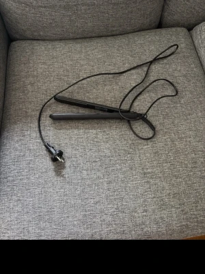 Svart plattång med sladd - Säljer en svart plattång med lång sladd och europeisk kontakt. Plattången har en smal och stilren design, perfekt för att styla håret. Passar dig som vill fixa frisyren snabbt och enkelt hemma.