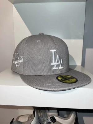 New Era Grå LA Keps - Säljer just nu en helt ny La keps i grå färg och använd 1 gång, säljer då den inte passar min huvudform! Bara att höra av sig vid funderingar eller budförslag✅Postar alltid inom 24 timmar📦
