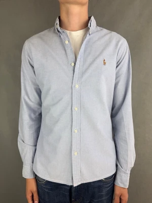 Ralph Lauren skjorta - Ralph Lauren Skjorta Märke: Polo Ralph Lauren Storlek: M Passform: Slimfit Färg: Ljusblå Skick: Mycket bra Beskrivning: små svättfläckar i armhåla. Modellen på bilden: 183 cm / 74 kg