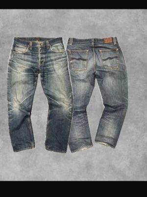 Blå slitna jeans från Nudie Jeans 90s vintage - Säljer ett par blå jeans från Nudie Jeans med snyggt slitna detaljer och klassisk femficksmodell. Jeansen har kontrastsömmar, läderpatch bak och vågig brodyr på bakfickorna. Tillverkade i denim med autentisk tvättad look.