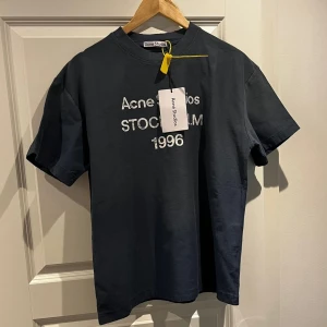 Acne Studio Stockholm 1996 Navy Blue  - Tjena! Säljer denna riktigt stilrena Acne Studios T-shirt i modellen Stockholm 1996 i navy blue. Enligt mig en av de snyggaste modellerna - enkel men sticker ändå ut. Tröjan är i storlek S och passar till det mesta, året runt. Köpt här på Plick och saljs vidare. Hör gärna av dig vid intresse!