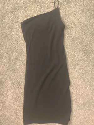 Svart oneshoulder klänning från Divided - Säljer en svart ribbad oneshoulder klänning från Divided.💕