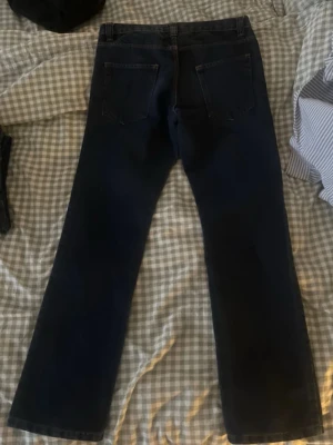 Mörkblå raka jeans från Identic (W:30 L:32) - Säljer ett par mörkblå jeans med rak passform och klassisk femficksdesign. Jeansen har knapp och dragkedja framtill samt kontrastsömmar. Perfekta till en avslappnad stil och funkar året runt.