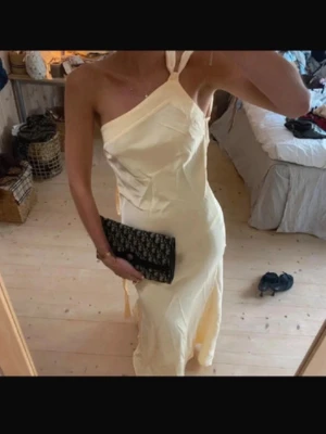 Ljusgul långklänning med öppen rygg💛 - Snygg ljusgul långklänning med omlott och knyt i ryggen, den är i satin som ger en elegant känsla. Perfekt till balen eller bröllop.😍