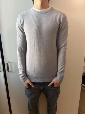 J Lindeberg merinoull tröja  - En stilren ljusgrå tröja med rund halsring från J Lindeberg, 100% merinoull och är nyskick använd max 3-5, inga defekter. Storlek L men passar som M, nypris-1300kr mitt pris-500kr