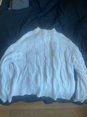 Vit kabelstickad tröja Noisy May - Vit kabelstickad tröja från Noisy May med klassiskt flätmönster. Tröjan har ribbade muddar vid ärmslut och nederkant samt en rund halsringning. Perfekt för lager-på-lager och en clean look.  Kontakta gärna ❤️