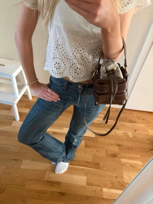 Blå bootcut jeans med fickdetaljer - Säljer ett par blå bootcut jeans med snygga fickdetaljer bak och klassisk femficksmodell. Jeansen har låg midja och är tillverkade i ett mjukt denimtyg med lätt tvättad look. Perfekta till en avslappnad och trendig stil. Super unika jeans köpta utomlands extremt svåra att få tag på, storlek 34/36❤️