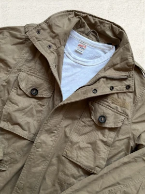 Superdry Fieldjacket - En mycket trevlig fieldjacket från Superdry i en fin ton av beige! Hör av dig vid frågor! 