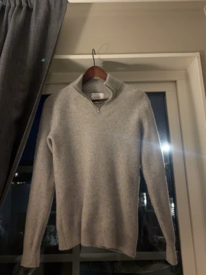 Ljusgrå stickad halvzip-tröja - Ljusgrå stickad tröja från vailent med halv dragkedja och hög krage. Tröjan har långa ärmar och ribbade muddar vid ärmslut och nederkant. Perfekt för lager-på-lager och enkel att matcha med olika outfits. Den är lite krympt i tvåtten dock så du bör inte va längre än 180