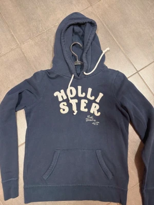 Hollister hoodie - Vintage! Hollister hoodie i fint skick och inget att klaga på! Inga defekter! Det står L på etiketten men den sitter som en S! Skriv till mig vid eventuella frågor jag svarar snabbt!