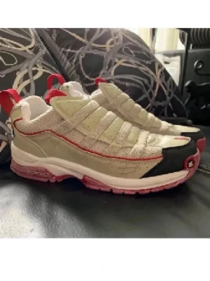 Beige och röda sneakers 38 - Unika sneakers från Royal Elastic i beige och vitt med röda detaljer och rosa sula. Skorna har en chunky siluett, mesh och mockaliknande material samt svart tåparti. RE logga syns bak på hälen och de har breda dragflikar i rött.