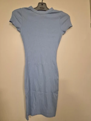 Ljusblå ribbad klänning från New Look - En ljusblå kortklänning med ribbad struktur och korta ärmar. Klänningen har en enkel och slim passform med rund halsringning, perfekt för en avslappnad och stilren look.