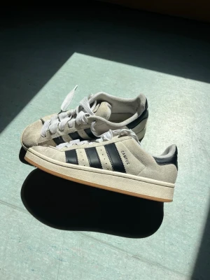 Adidas Campus sneakers beige/svart - Säljer ett par klassiska Adidas Campus sneakers i beige mocka med svarta läderdetaljer och vita snören. 