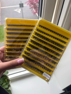 Svarta individuella ögonfransar - Två förpackningar med svarta individuella ögonfransar i olika längder. Fransarna kommer i gula plastaskar och är perfekta för att skapa en fyllig och naturlig look. Passar dig som vill bygga upp volym eller förlänga dina egna fransar. Fransarna är syntetiska och lätta att applicera.