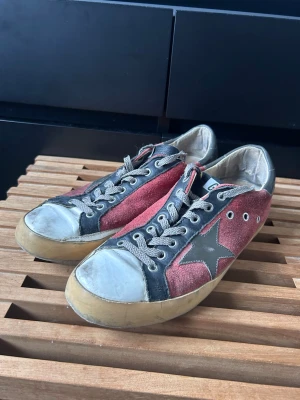 Golden Goose skor - Säljer dessa golden goose superstars i rätt bra skick, anmärkning finns på undersida skon och i hälarna men inget som man tänker på vid användning. Se bilder. Storlek 41. Inga tillbehör tillkommer.