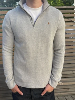 Ljusgrå halvzip från Ralph Lauren - Säljer en stilren ljusgrå halfzip från Ralph Lauren. Storlek M, modellen är 185cm. Skriv för yttligare frågor!