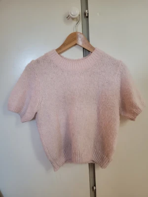 Ljusrosa stickad tröja Gina Tricot - Supersöt ljusrosa stickad tröja från Gina Tricot med korta ärmar. Lite nopprig!