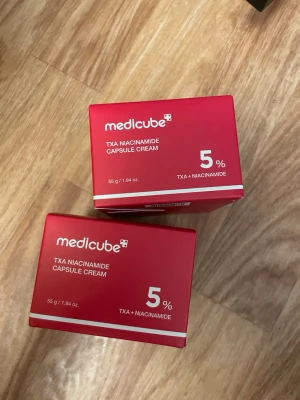 Medikube TXA Niacinamide Cream 5% (2 för 1) - Båda förpackningarna är helt oöppnade och fortfarande förseglade. TXA Niacinamide Capsule Cream från medicube med 5% TXA och niacinamid. Kommer i en röd förpackning och innehåller 55 g. Perfekt för dig som vill boosta hudvårdsrutinen med kapselkräm som fokuserar på lyster och jämnare hudton.