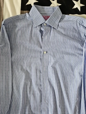 Blårutig skjorta från Lorenzo Uomo - Snygg blårutig skjorta från Lorenzo Uomo i trim fit-modell. Skjortan är tillverkad i 100% bomull och har klassisk krage samt knappar framtill. Perfekt för dig som gillar stilrena och tidlösa mönster.