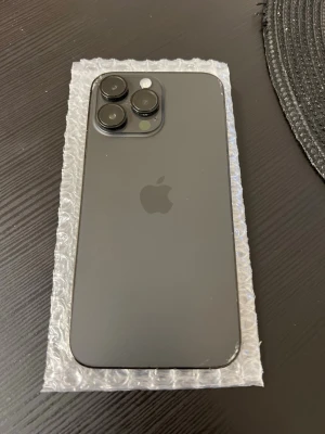 iPhone 14 Pro max  svart med trippelkamera - Snygg svart iPhone Pro med stilren design och baksida i matt glas. Telefonen har tre stora kameralinser och Apple-loggan på baksidan. Perfekt för dig som gillar modern teknik och vill ha en mobil med grym kamera och premiumkänsla. back is little crack, battri 87%