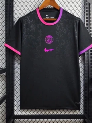 Svart PSG x Nike t-shirt med lila detaljer - Snygg svart PSG t-shirt från Nike med diskret blommönster i tyget. Lila och rosa detaljer vid halsringning och ärmslut, samt PSG-logga och Nike swoosh i rosa/lila på bröstet. Perfekt för dig som gillar sportig streetstyle.