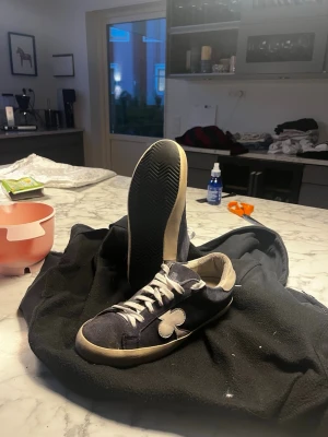 The gallerist  - Säljer ett Par gallerist blå sneakers i mörkblå mocka med vit design på sidan och vita snören. Klassisk låg modell med vit sula och diskret logga på plösen. Perfekta för dig som gillar streetwear och vill sticka ut lite extra. Med en exklusiv look. Vid storlek passar 41-43 vid frågor eller funderingar skriv ett meddelande 