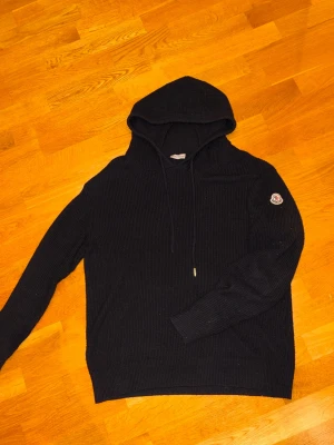 Svart stickad hoodie från Moncler - Säljer nu denna stickade moncler hoodien i bra skick✅ Finns tecken på användning då ena snöret tyvärr har tappat sin metallände, utöver det är den i oerhört bra skick och i ett skönt material🧶 Hör av er vid frågor eller önskade bilder! 💥 Mvh John🍾