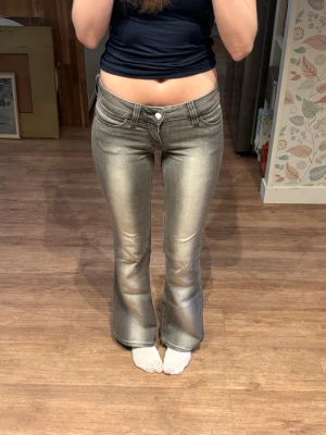 Cheap Monday Jeans - Jättefina lågmidjade bootcut jeans från Cheap Monday i storlek 27/32. Gråa med neon gröna detaljer. Materialet är väldigt stretchigt och så så skönt!