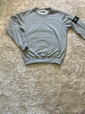 Grå sweatshirt från Stone Island - Inge skador eller nått, helt oanvänd! Sitter lite lite slim fit jämfört med andra hoodies
