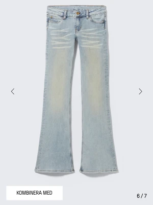 Ljusblå bootcut jeans med slitningar - Ljusblå jeans med bootcut passform och diskreta slitningar framtill. Klassisk femficksdesign och knappgylf. Jeansen har en lätt tvättad look och är tillverkade i denim med stretch för extra komfort. I storlek 29/32