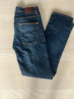 Mörkblå jeans från Nudie Jeans - Snygga mörkblå jeans från Nudie jeans. Jeansen har inga defekter. Storlek: W33 och L32. Kan sänka vid snabb affär! Hör av er om frågor m.m!