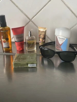 Svarta  solglasögon  + Skönhetsprodukter  - Klassiska svarta Wayfarer-inspirerade solglasögon med breda bågar och mörka glas. Snygg och tidlös design som passar till alla outfits. Bågarna är i plast och har en cool vibe som aldrig går ur tiden.lite lagat på båge funkar fint ändå. Parfymen är nlitectagit i  annars  allt annat oupptaget 