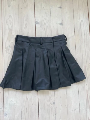 Zara kjol  - Säljer en super fin kjol i läder från Zara med fina volanger. Den är endast använd en gång!