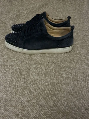 Louboutin - Säljer ett par marin blå sneakers från Christian Louboutin med storleken 42 passar upp till 43, 9/10 skick, Hör av er vid intresse, för priset kan diskuteras!