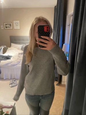 Grå stickad tröja från Vero Moda - Mysig grå stickad tröja från Vero Moda med rund halsringning och långa ärmar. Den är lite nopprig!